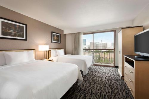 ラスベガスにあるエンバシー スイーツ バイ ヒルトン コンベンションセンター ラスベガスのベッド2台、薄型テレビが備わるホテルルームです。