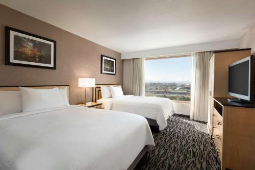 a hotel room with two beds and a flat screen tv at Embassy Suites by Hilton Convention Center Las Vegas in Las Vegas