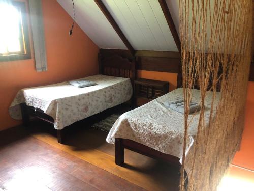 Camera mansardata con 2 letti e finestra. di Sítio Chalé 3Ipes a Senador José Bento