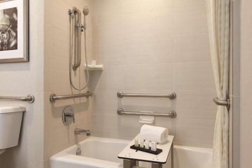 a bathroom with a tub and a toilet and a sink at Embassy Suites by Hilton Temecula Valley Wine Country in Temecula