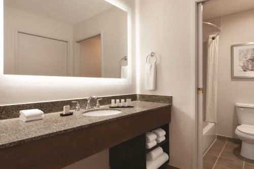 a bathroom with a sink and a toilet at Embassy Suites by Hilton Temecula Valley Wine Country in Temecula