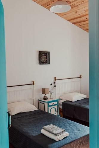 a room with two beds and a table with a lamp at Casa Margarida in Albernoa