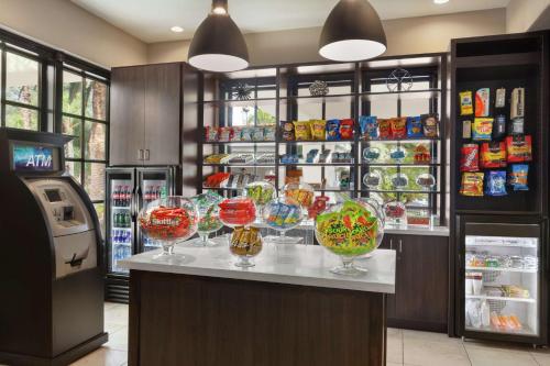a candy store with wine glasses on a counter at Embassy Suites by Hilton Arcadia-Pasadena Area in Arcadia