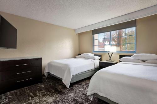 a hotel room with two beds and a window at Embassy Suites by Hilton Arcadia-Pasadena Area in Arcadia