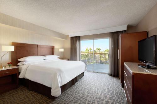 a hotel room with a large bed and a television at Embassy Suites by Hilton Santa Ana Orange County Airport in Santa Ana