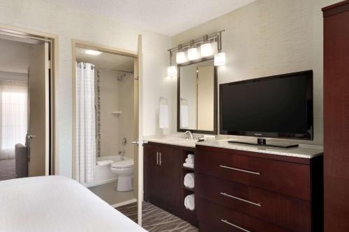 Schlafzimmer mit einem TV und einem Bad mit einem Bett in der Unterkunft Embassy Suites by Hilton Lompoc Central Coast in Lompoc