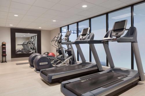 a gym with treadmills and ellipticals in a room with windows at Embassy Suites San Luis Obispo in San Luis Obispo