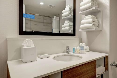 a bathroom with a sink and a mirror and towels at Hampton Inn Egg Harbor Township Atlantic City in Egg Harbor Township