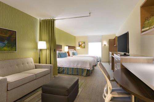 une chambre d'hôtel avec un lit et un canapé dans l'établissement Home2 Suites by Hilton Grovetown Augusta Area, à Augusta