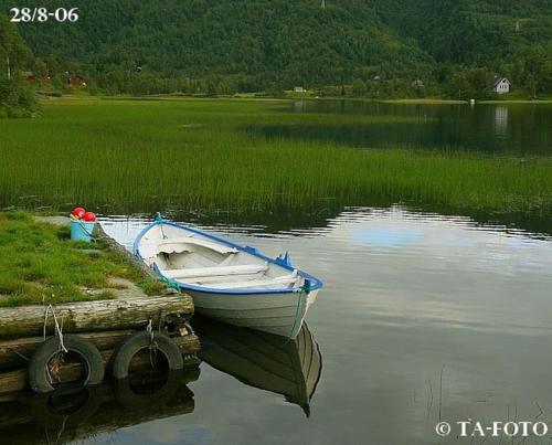 un barco está atracado en un muelle en un lago en Panoramahytte en Norheimsund