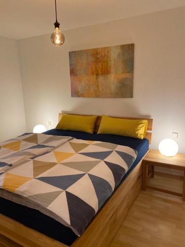 a bed in a room with two lamps and a painting at Harmony Apartment, your holiday home in Rust with balcony & river-view, 5min to Europa-Park in Rust
