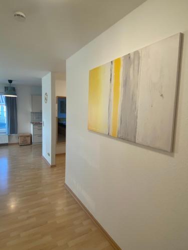 a room with a white wall with paintings on it at Harmony Apartment, your holiday home in Rust with balcony & river-view, 5min to Europa-Park in Rust