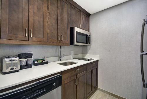 a kitchen with a sink and a microwave at Homewood Suites by Hilton Athens Downtown University Area in Athens