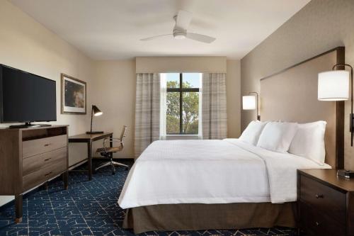 a hotel room with a bed and a flat screen tv at Homewood Suites by Hilton Albany Crossgates Mall in Albany