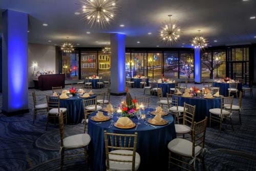 a banquet hall with blue tables and chairs and chandeliers at Hilton Albany in Albany