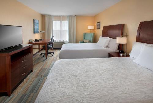 a hotel room with two beds and a flat screen tv at Hilton Garden Inn Albany Medical Center in Albany
