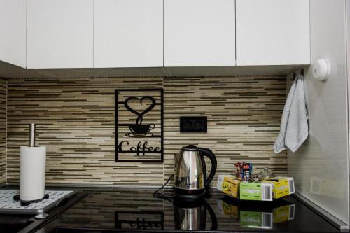 a kitchen counter with a coffee maker on a stove at Luka Apartments Flatiron in Skopje