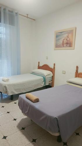 a room with two beds and a window at Hostal Alboran in Motril