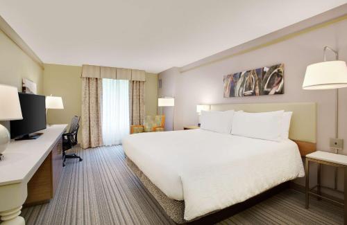 a hotel room with a large bed and a desk at Hilton Garden Inn Saratoga Springs in Saratoga Springs