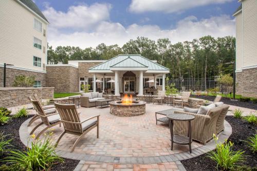 a patio with a fire pit with chairs and tables at Homewood Suites By Hilton Saratoga Springs in Saratoga Springs