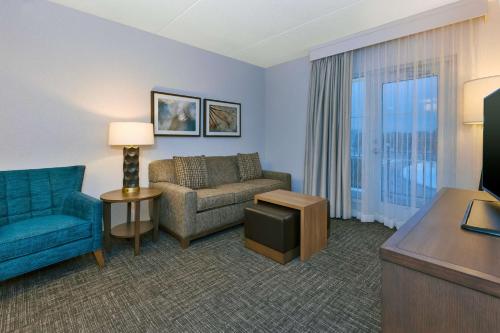 a living room with a couch and a chair at Homewood Suites By Hilton Saratoga Springs in Saratoga Springs