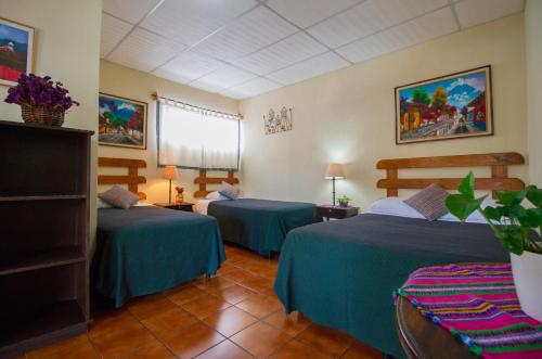 a hotel room with two beds in a room at Posada Do&ntilde;a Luisa in Antigua Guatemala