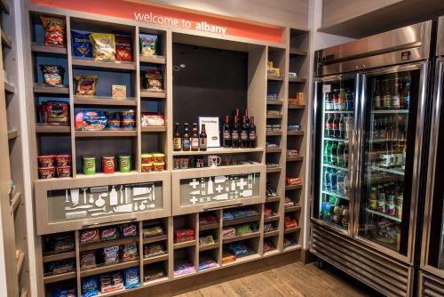 a store aisle with a refrigerator and shelves of food at Hampton Inn Albany-Western Ave/University Area, NY in Albany
