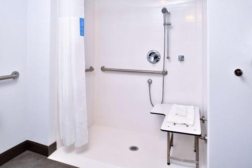 uma casa de banho com um chuveiro e um lavatório. em Hampton Inn Cedar Falls Downtown, Ia em Cedar Falls
