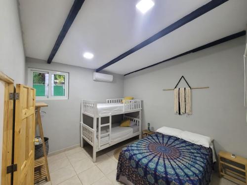 a bedroom with a bed and a crib at LOOKING2GOOD in El Zonte