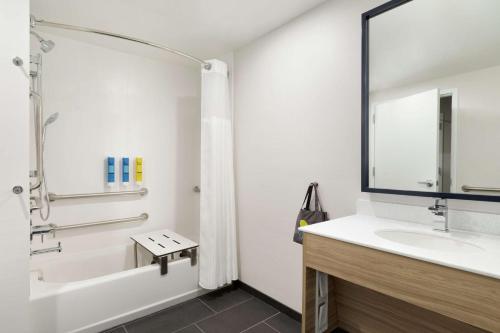 a bathroom with a sink and a tub and a shower at Tru by Hilton Albany Crossgates Mall in Albany