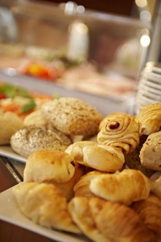 a bunch of pastries on a plate on a table at Hotel Stuttgart Sindelfingen City by Tulip Inn in Sindelfingen