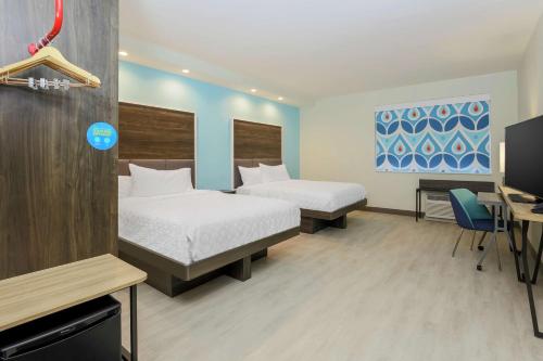 um quarto de hotel com duas camas e uma secretária e uma televisão em Tru by Hilton Amarillo West em Amarillo