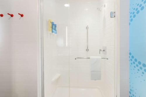 uma casa de banho branca com um chuveiro com uma porta de vidro em Tru by Hilton Amarillo West em Amarillo