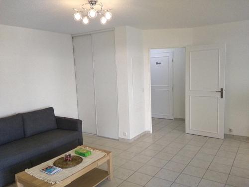 ein Wohnzimmer mit einem Sofa und einem Tisch in der Unterkunft Appartement T2, 4 personnes, disponible jusqu au Samedi 2 sept 2023 in Le Cannet-des-Maures
