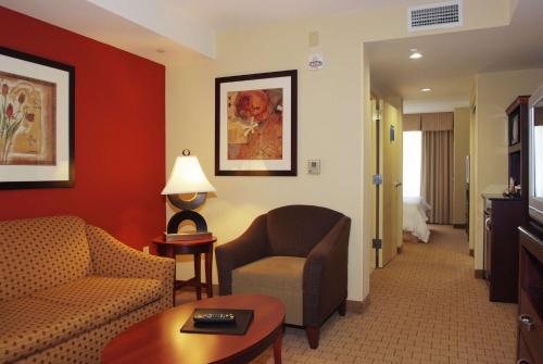a living room with a couch and a chair in a hotel room at Hilton Garden Inn Anderson in Anderson