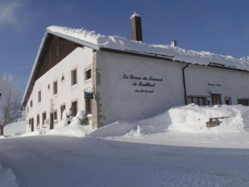 a snow covered building with a sign on the side of it at B&B La Ferme De Pouillerel in La Chaux-de-Fonds