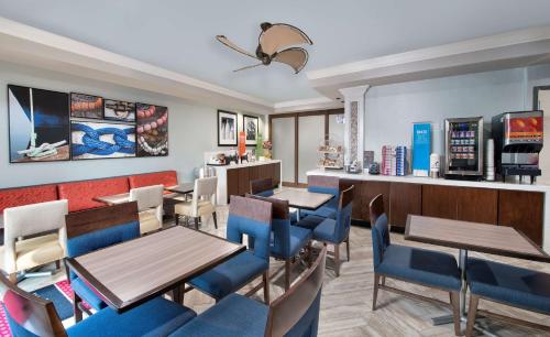 un ristorante con tavoli, sedie e un bancone di Hampton Inn Naples - I-75 a Naples