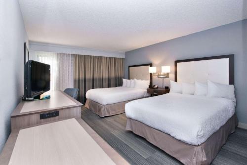 a hotel room with two beds and a flat screen tv at Hampton Inn Naples - I-75 in Naples