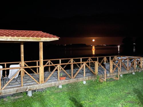 a wooden bridge over the water at night at Cabañas y Tinajas Rio Quenuir in Maullín