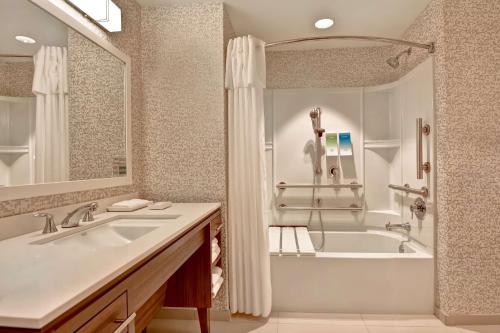 bagno con vasca e lavandino di Home2 Suites By Hilton Naples I-75 Pine Ridge Road a Naples