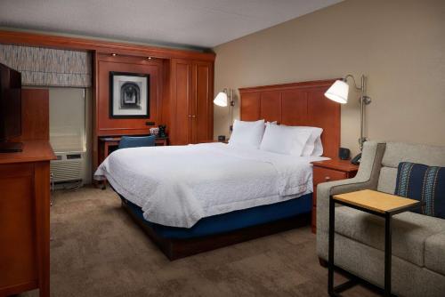 a hotel room with a bed and a couch at Hampton Inn Ann Arbor-South in Ann Arbor