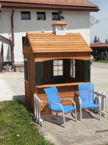 a small building with two chairs and a table and a roof at B&B La Ferme De Pouillerel in La Chaux-de-Fonds