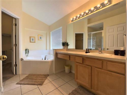 a bathroom with a tub and a sink and a bath tub at Restful Single Home with BBQ Heated Pool and SPA in Kissimmee