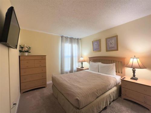 a bedroom with a bed and a dresser and a television at Restful Single Home with BBQ Heated Pool and SPA in Kissimmee
