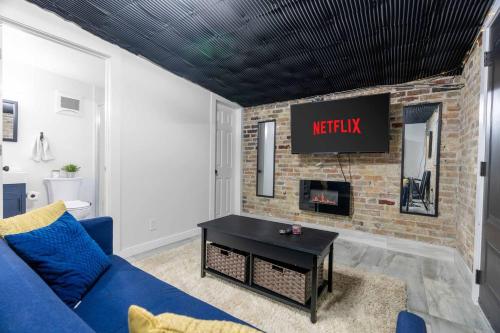 a living room with a blue couch and a brick fireplace at London Downtown Home in London