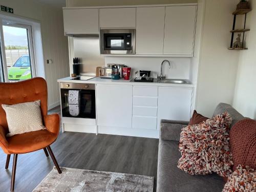 a living room with a couch and a kitchen at Green Law - Dog Friendly in Penicuik