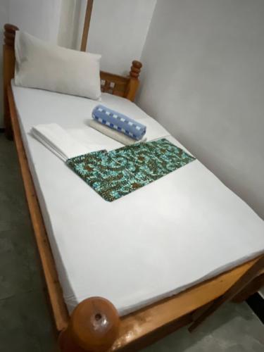 a bed with a wooden frame with a pillow and a remote at PALM - 2minutes walk to the beach in Nungwi