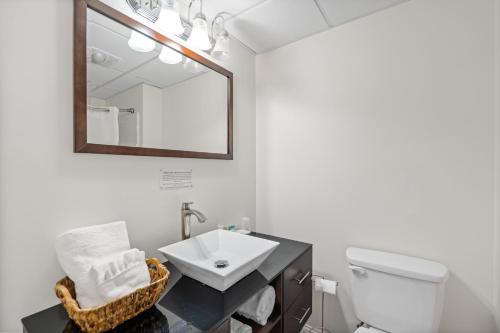 een badkamer met een wastafel, een toilet en een spiegel bij Trade Winds Inn in Rockland