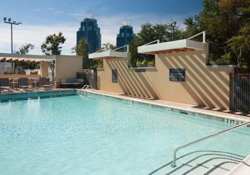 a large swimming pool with a city skyline in the background at Home2 Suites By Hilton Atlanta Perimeter Center in Atlanta