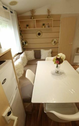une pièce avec une table avec un vase de fleurs dessus dans l'établissement Ghislain et Pat, à Saint-Chéron
